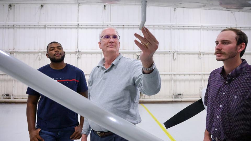 Dr. Paul Clark, center, looks closely at an airplane wing with flight students Brandon Nelson, left, and Branson Cruse, right. Clark teaches flight lessons as a sideline to his career as a history professor at West Texas A&M University.