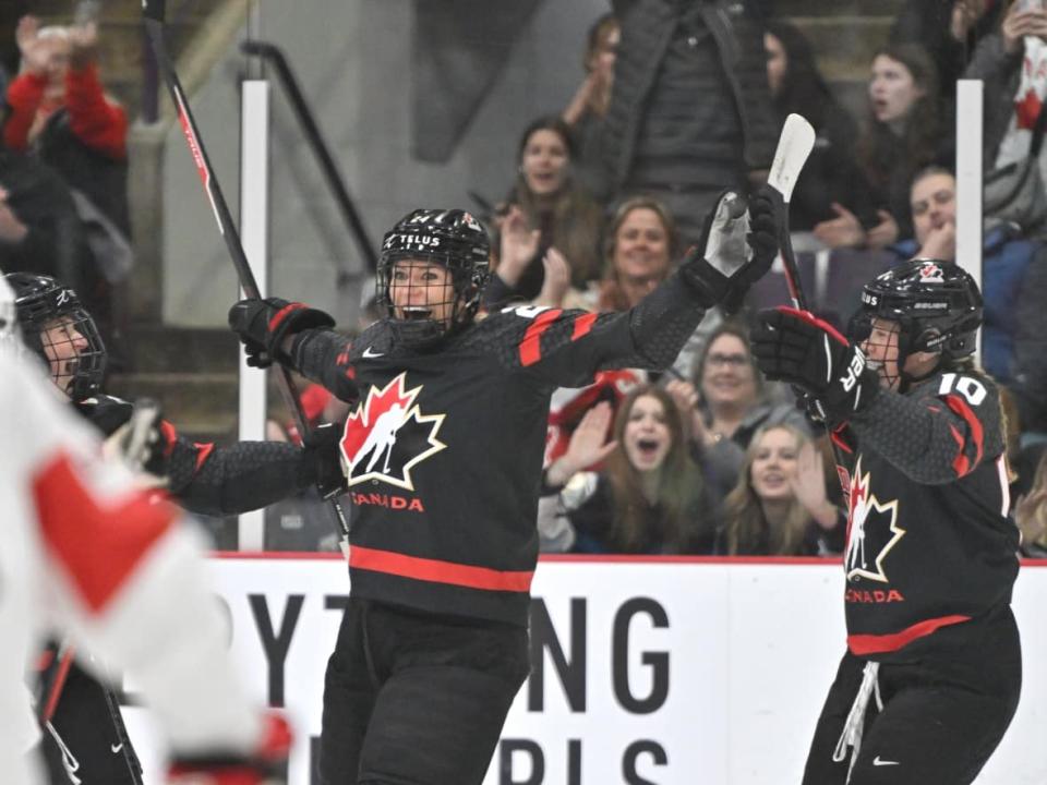 Canada's Natalie Spooner, middle, celebrates after scoring a goal during the first period of Canada's 4-0 win over Switzerland at the women's world hockey championship on Wednesday in Brampton, Ont.  (Dan Hamilton-USA TODAY Sports via Reuters - image credit)