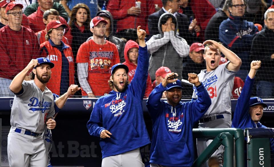 Dodger players and coaches celebrate in the dugout.