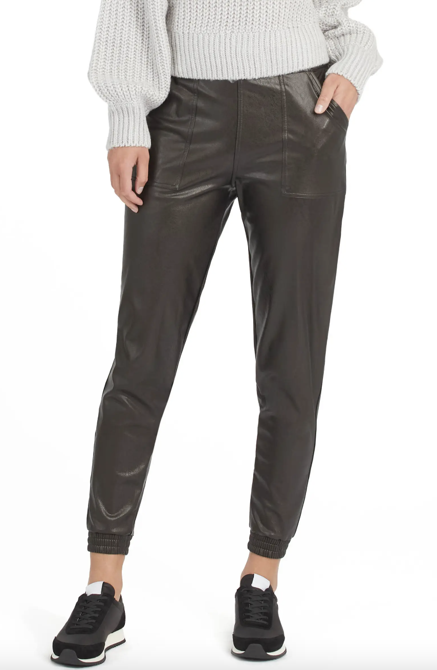 woman wearing grey sweater, black sneakers and black pants Spanx Leather-Like Jogger (Photo via Nordstrom)