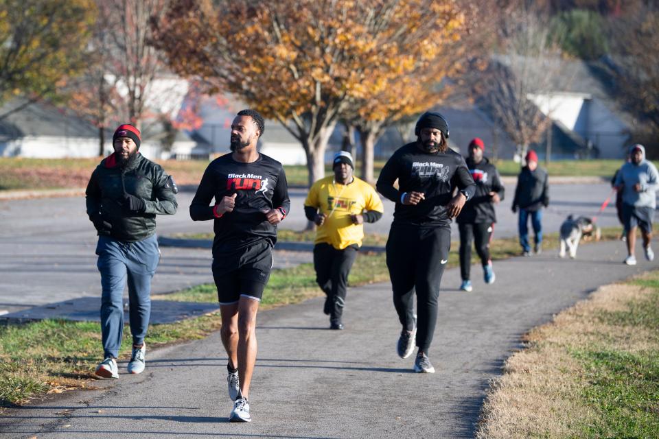 Phillip Tucker (center), co-captain of the local local chapter of Black Men Run, leads a group at Victor Ashe Park.