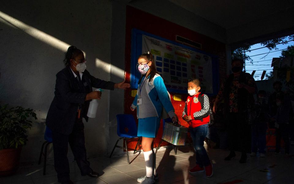 A girl is sanitised as she enters a school during the resumption of face-to-face classes in Mexico City on June 7 - AFP