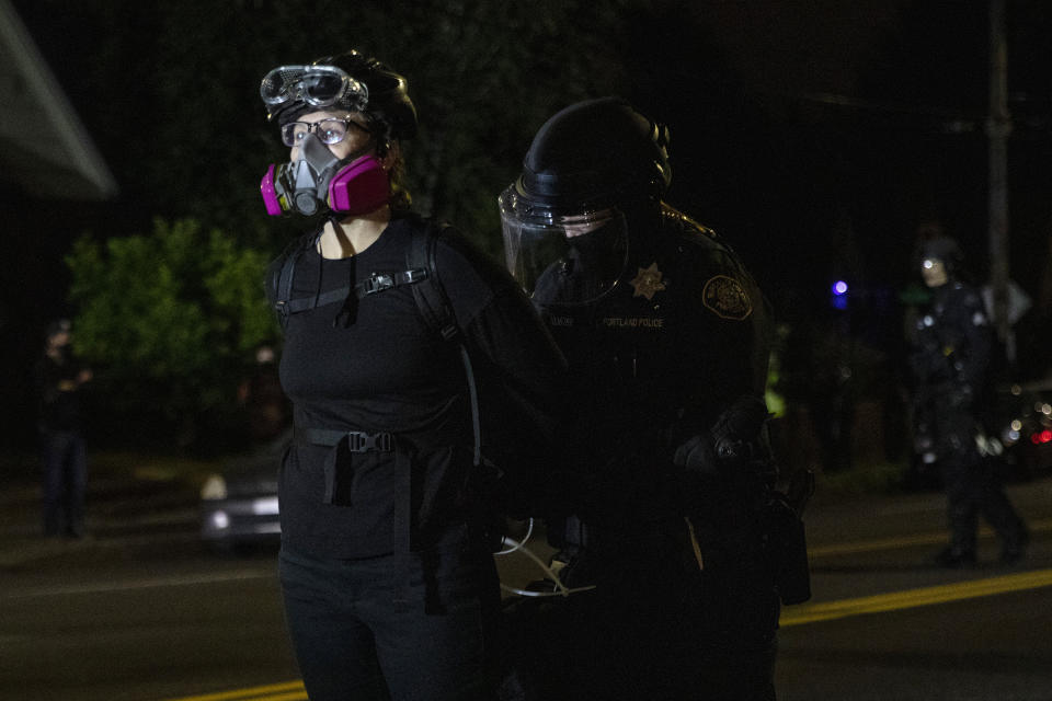 Portland police make arrests on the scene of the nightly protests at a Portland police precinct on Sunday, Aug. 30, 2020 in Portland, Ore. Oregon State Police will return to Portland to help local authorities after the fatal shooting of a man following clashes between President Donald Trump supporters and counter-protesters that led to an argument between the president and the city's mayor over who was to blame for the violence. (AP Photo/Paula Bronstein)