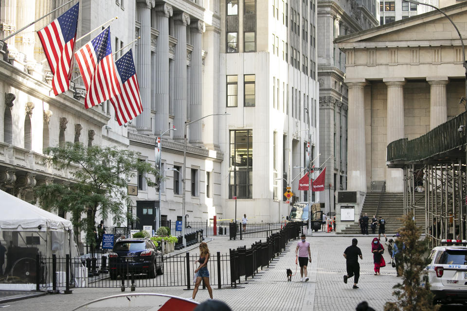 FILE - People walk by the New York Stock Exchange, left, Tuesday, July 21, 2020. Wall Street is drifting in early trading on Monday, Aug. 10, after President Donald Trump announced several stopgap moves to aid the economy. (AP Photo/Mark Lennihan)