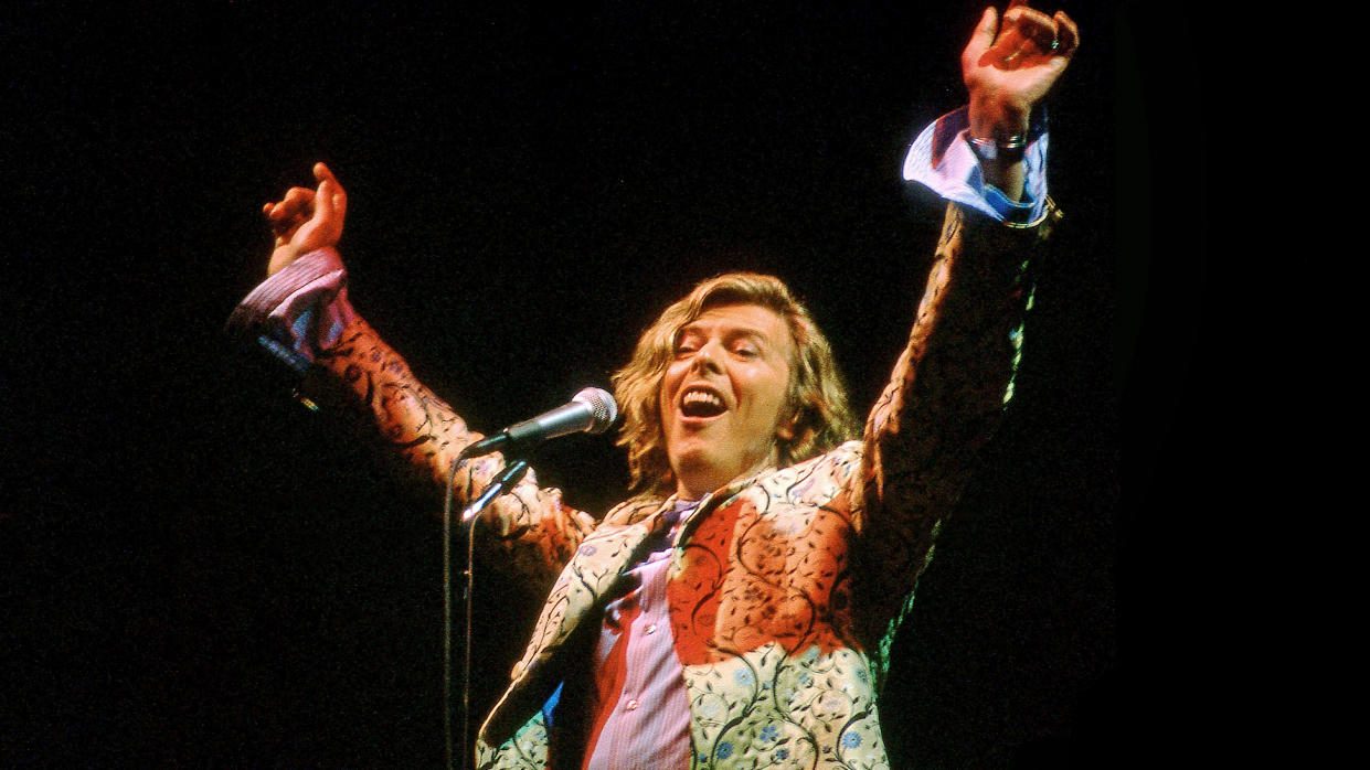  David Bowie performs live on the Pyramid stage wearing a coat designed by Alexander McQueen, at the Glastonbury festival at Worthy Farm on June 25, 2000 in Pilton, United Kingdom. 