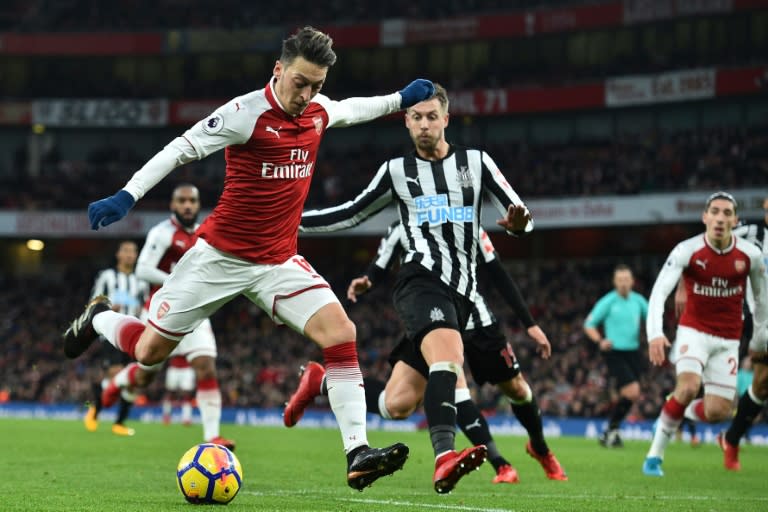 Arsenal midfielder Mesut Ozil (L) prepares to shoot against Newcastle United at the Emirates Stadium in London on December 16, 2017