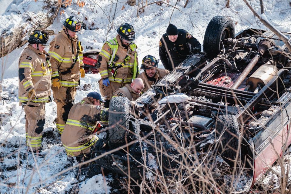 Firefighters from Dover and New Philadelphia work at the scene of a single-vehicle rollover crash in the 4800 block of state Route 800 on Tuesday in Dover Township. The Ohio State Highway Patrol reported that the driver of a southbound sport utility vehicle crossed the center of the road, drove off the pavement  and crashed the SUV onto its roof near the Tuscarawas River. The driver was taken to a hospital. He was alone in the vehicle.