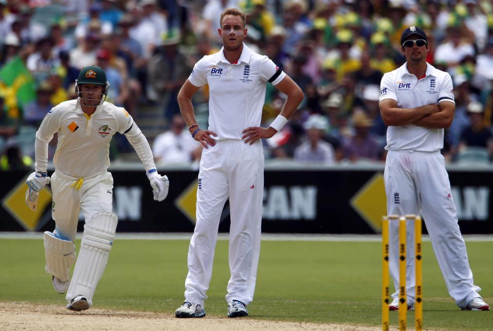 Australia's captain Michael Clarke (L) runs between wickets as England's captain Alastair Cook (R) and bowler Stuart Broad look on during the second day's play in the second Ashes cricket test at the Adelaide Oval December 6, 2013.