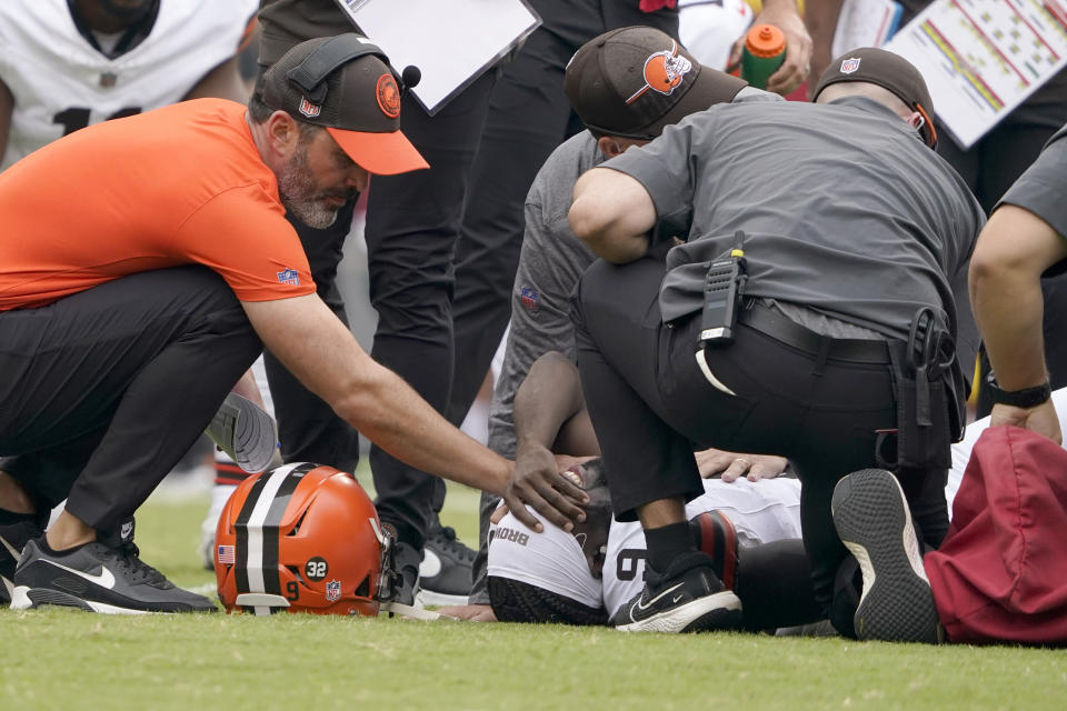 Cleveland Browns wide receiver Jakeem Grant Sr. (9) is checked on by Browns head coach Kevin Stefanski, left, and trainers after being injured on the opening kickoff during the first half of an NFL preseason football game Saturday, Aug. 26, 2023, in Kansas City, Mo. (AP Photo/Ed Zurga)