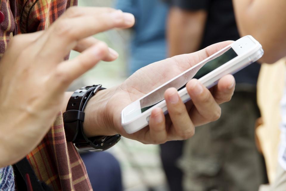 A teenage girl writes a text message on her phone.