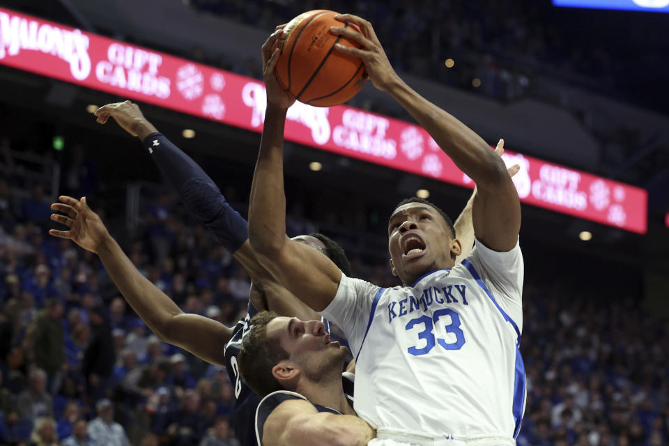 FILE - Kentucky's Ugonna Onyenso (33) is pressured by Yale's John Poulakidas, middle and Bez Mbeng, left, during the first half of an NCAA college basketball game in Lexington, Ky., Saturday, Dec. 10, 2022. There’s also no telling when Onyenso returns from a broken foot sustained this fall. (AP Photo/James Crisp, File)