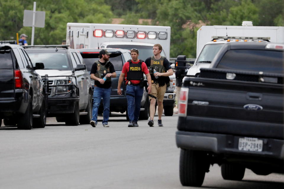 Law enforcement officers walk near the scene of a shooting at Robb Elementary School in Uvalde, Texas, U.S. May 24, 2022.  REUTERS/Marco Bello