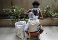 In this Saturday, May 23, 2020 photo, an Ethiopian worker packs food at the office of Egna Legna, meaning “from us migrants to us migrants” in Amharic, Ethiopia's official language, which offers food packages for some who lost their jobs and helps others pay rent, in Beirut, Lebanon. Some 250,000 registered migrant laborers in Lebanon — maids, garbage collectors, farm hands and construction workers — are growing more desperate as a crippling economic and financial crisis sets in, coupled with coronavirus restrictions. With no functioning airports and exorbitant costs of repatriation flights, many are trapped, unable to go home. (AP Photo/Hussein Malla)