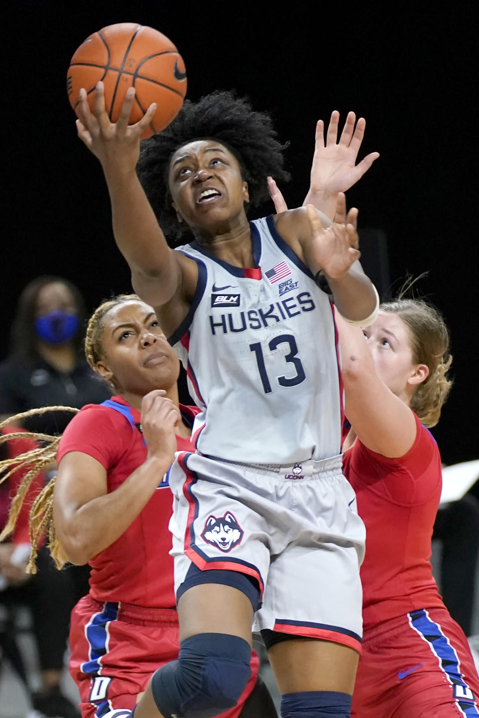 Connecticut's Christyn Williams (13) scores past DePaul's Deja Church, left, and Evina Westbrook during the first half of an NCAA college basketball game Sunday, Jan. 31, 2021, in Chicago. (AP Photo/Charles Rex Arbogast)