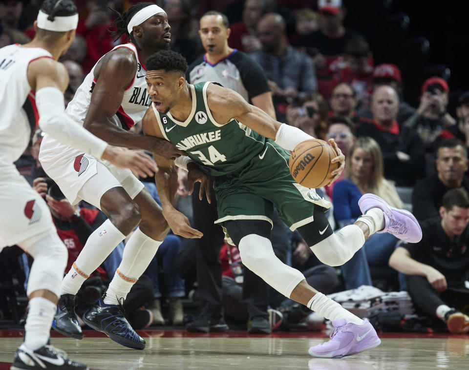 Milwaukee Bucks forward Giannis Antetokounmpo, right, drives to the basket toward Portland Trail Blazers forward Jerami Grant during the first half of an NBA basketball game in Portland, Ore., Monday, Feb. 6, 2023. (AP Photo/Craig Mitchelldyer)