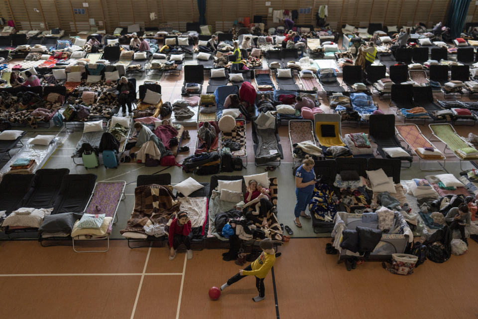 People who fled the war in Ukraine rest inside an indoor sports stadium being used as a refugee center, in the village of Medyka, a border crossing between Poland and Ukraine, on Tuesday, March 15, 2022.(AP Photo/Petros Giannakouris)