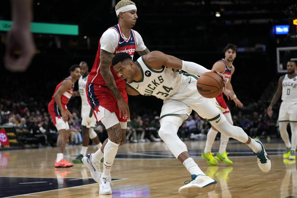 Milwaukee Bucks forward Giannis Antetokounmpo (34) drives against Washington Wizards forward Kyle Kuzma during the first half of an NBA basketball game, Monday, Nov. 20, 2023, in Washington. (AP Photo/Mark Schiefelbein)