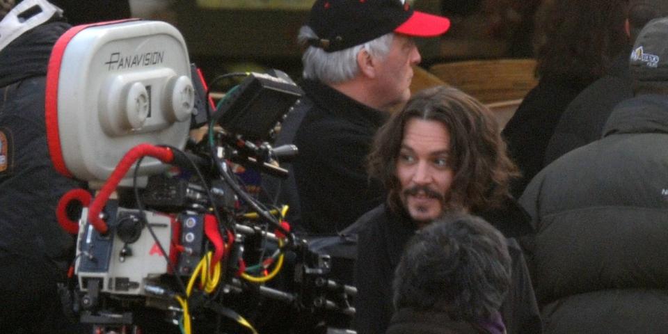 Johnny Depp pictured in a crowd with a movie camera in the foreground, on the set of "The Tourist" in 2010.