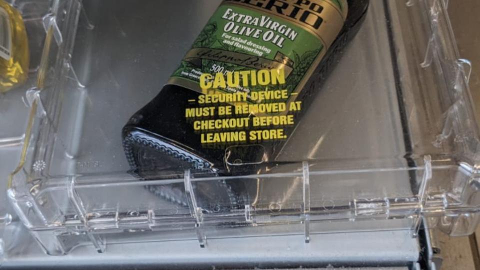 Extra virgin olive oil being kept in a plastic security case a Co-op in Norwich. (SWNS)