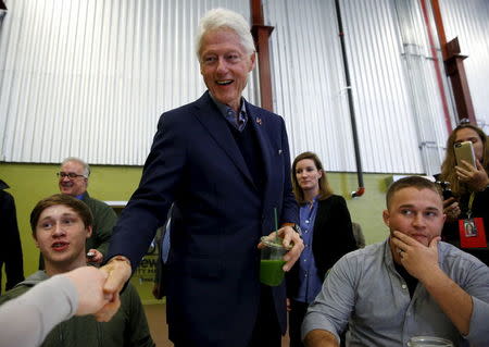 Former U.S. President Bill Clinton (C) greets customers and employees while campaigning for his wife, Democratic presidential candidate Hillary Clinton, at the NewBo Market in Cedar Rapids, Iowa in this January 7, 2016 file photo. REUTERS/Aaron P. Bernstein/Files