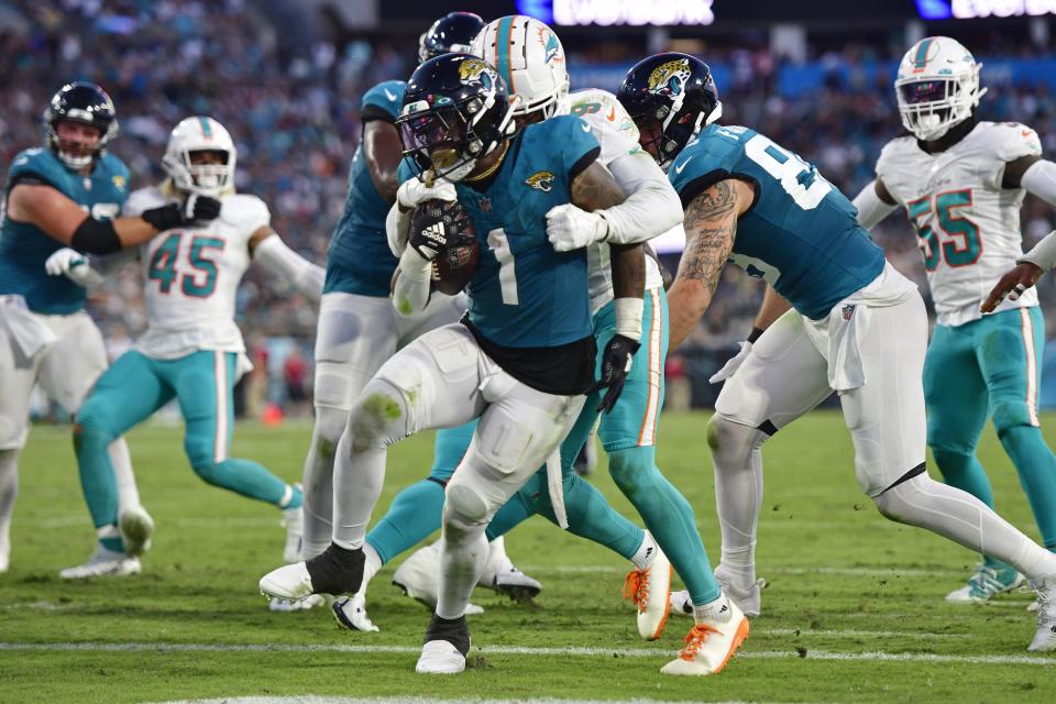 Jacksonville Jaguars running back Travis Etienne Jr. (1) scores a touchdown against Miami Dolphins cornerback Noah Igbinoghene (9) during the second quarter of a preseason matchup Saturday, Aug. 26, 2023 at EverBank Stadium in Jacksonville, Fla. [Corey Perrine/Florida Times-Union]