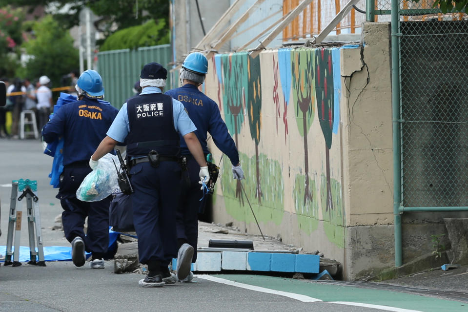 <p>Police officers investigate the site where an elementary school student was killed after the walls next to the school pool had collapsed due to a magnitude 6.1 earthquake in Takatsuki, Osaka, Japan, on Monday, June 18, 2018. (Photo: Buddhika Weerasinghe/Bloomberg via Getty Images) </p>