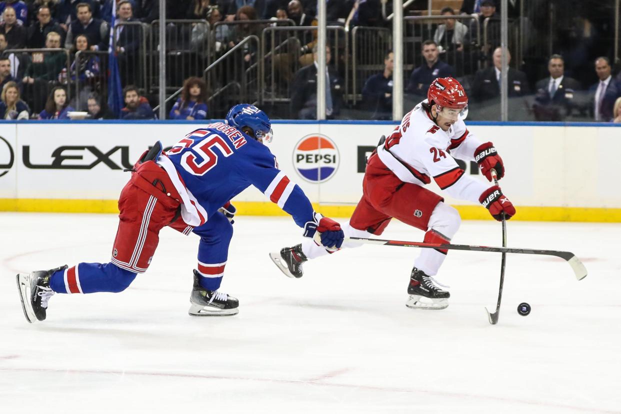 Nov 2, 2023; New York, New York, USA; Carolina Hurricanes center Seth Jarvis (24) skates past New York Rangers defenseman Ryan Lindgren (55) for a shot on goal in the first period at Madison Square Garden. Mandatory Credit: Wendell Cruz-USA TODAY Sports