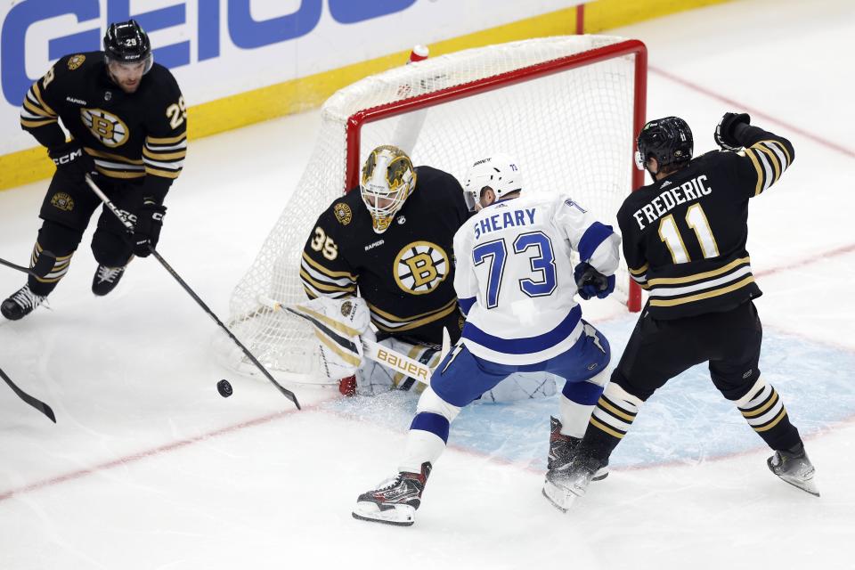 Boston Bruins' Linus Ullmark (35) blocks a shot by Tampa Bay Lightning's Conor Sheary (73) as Bruins' Trent Frederic (11) defends during the first period of an NHL hockey game, Saturday, Jan. 6, 2024, in Boston. (AP Photo/Michael Dwyer)