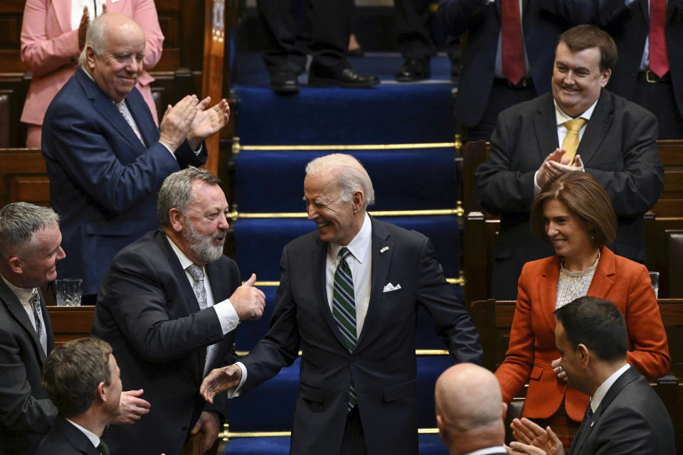 Members of parliament stand as President Joe Biden walks down the steps before he addresses members of the Irish parliament at Leinster House in Dublin, Thursday, April 13, 2023. (Kenny Holston/The New York Times via AP, Pool)