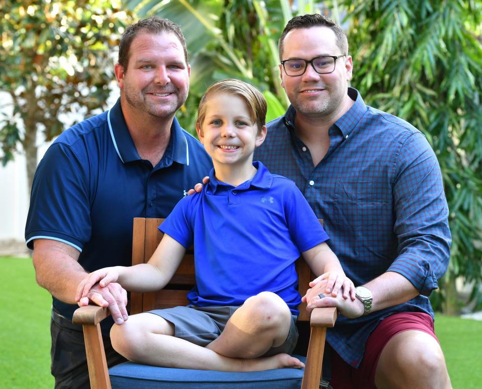 Jordan Letschert, left, and Robby Price, right, with their son, Kellen Letschert-Price at their home in Sarasota. 