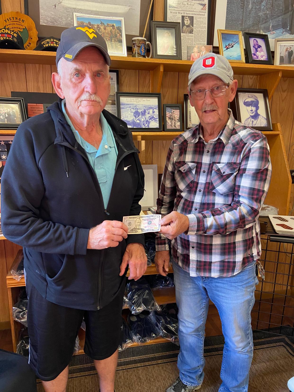 Dean Pace, right, presents Eddie Shiflett with the $50 he owed to Eddie's brother, David.