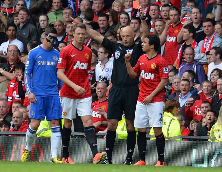 Referee Howard Webb (2R) shows a red card to Manchester United's Brazilian defender Rafael Da Silva on May 5, 2013