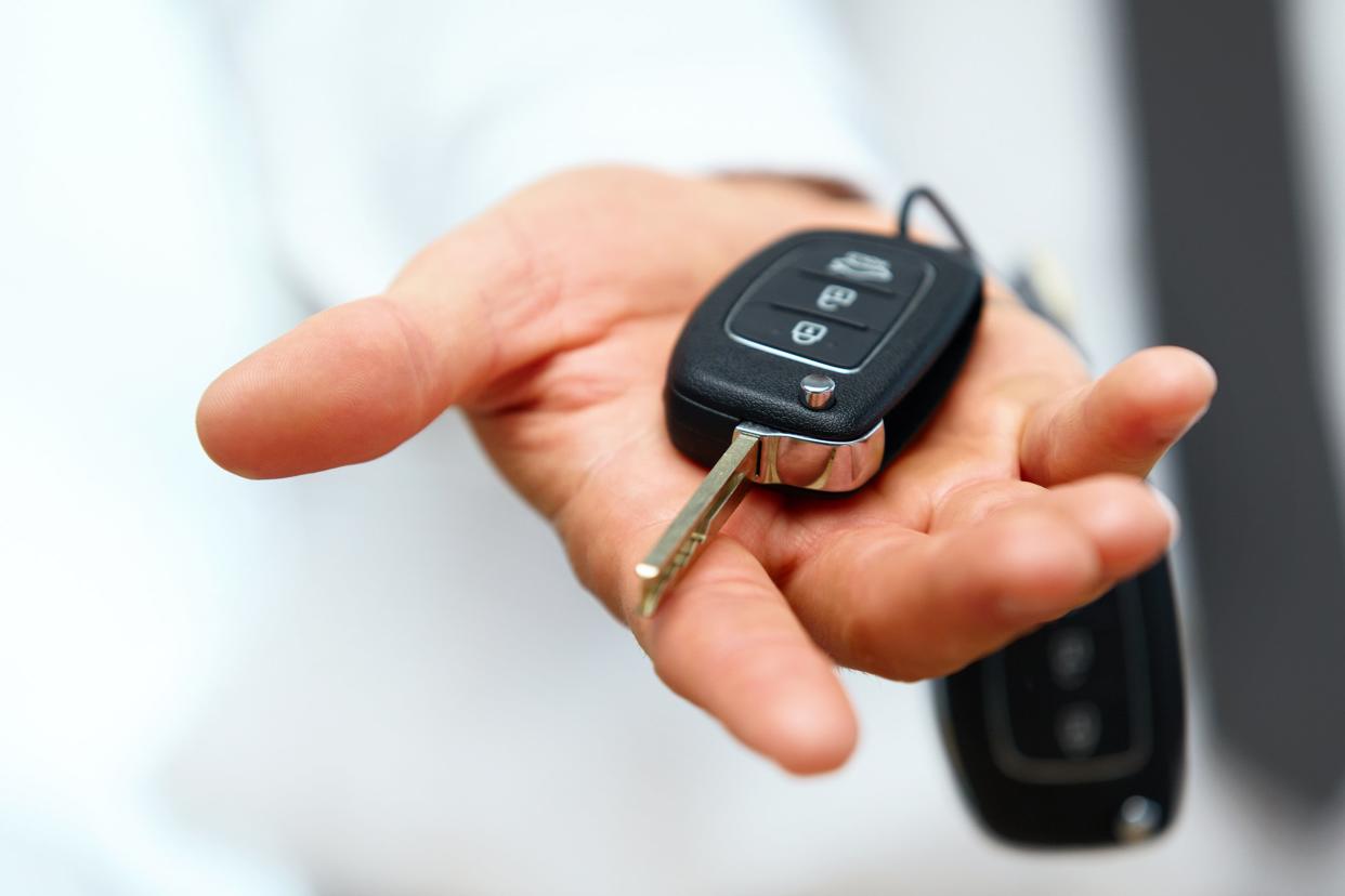 Close-up of hand giving car keys