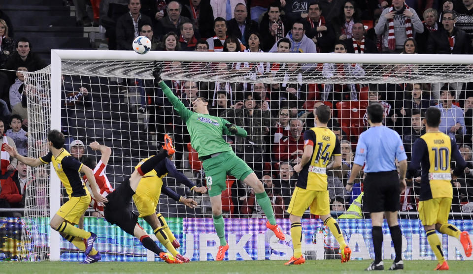 Atletico de Madrid's goalkeper Thibaut Courtois of Belgium, center with green shirt, tries to catch the ball during their Spanish League soccer match against Athletic Bilbao, at San Mames stadium in Bilbao, Spain, Saturday, March 29, 2014. (AP Photo/Alvaro Barrientos)e