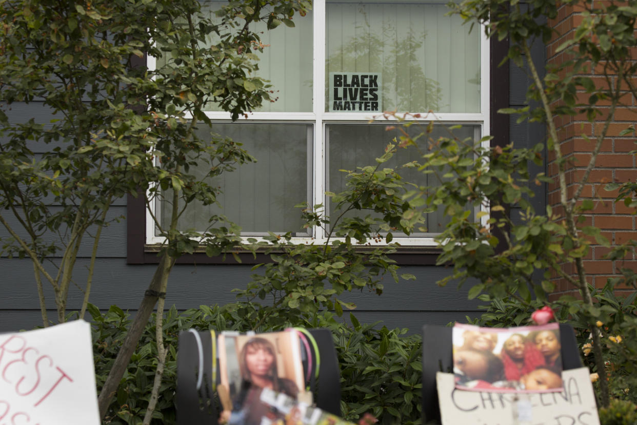 A Black Lives Matter sign sits in a window behind a memorial for Charleena Lyles at the Seattle apartment building where she was killed. (Photo: David Ryder via Getty Images)