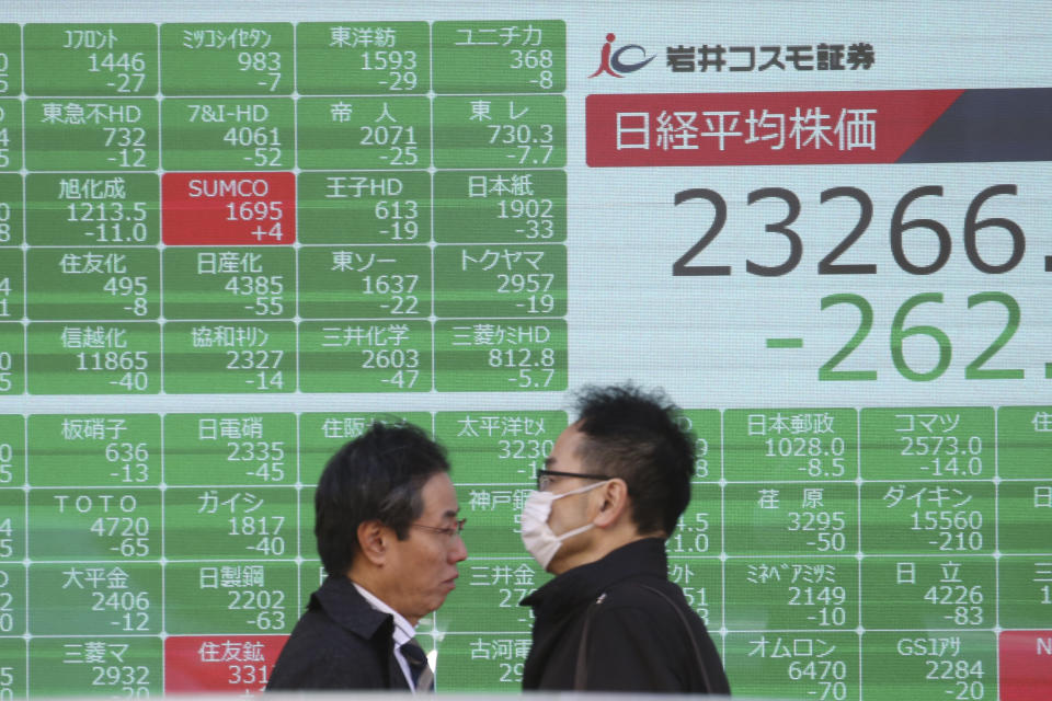 People walk by an electronic stock board of a securities firm in Tokyo, Tuesday, Dec. 3, 2019. Asian shares slipped Tuesday, following a drop on Wall Street amid pessimism over U.S.-China trade tensions. (AP Photo/Koji Sasahara)