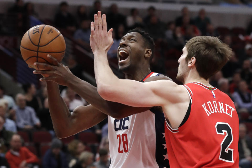 Washington Wizards center Ian Mahinmi, left, drives to the basket as Chicago Bulls forward Luke Kornet defends during the first half of an NBA basketball game in Chicago, Wednesday, Jan. 15, 2020. (AP Photo/Nam Y. Huh)