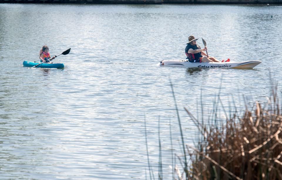 Kayakers take advantage of the warm, sunny day to paddle on the waters of Lodi Lake in Lodi.