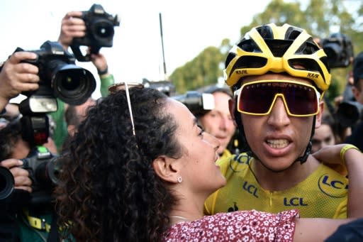 Egan Bernal, wearing the overall leader's yellow jersey, is congratulated by his girlfriend Xiomy Guerrero