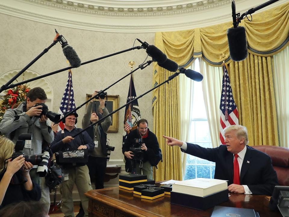 Donald Trump gestures to cameras in the Oval Office in 2017