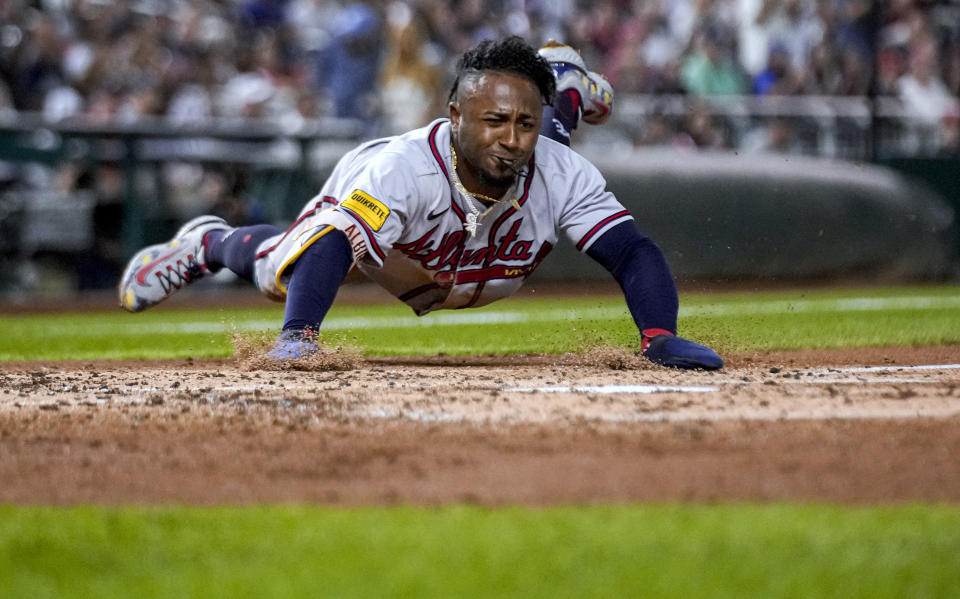 Atlanta Braves' Ozzie Albies slides across home plate to score against the Washington Nationals during the third inning of a baseball game at Nationals Park, Thursday, Sept. 21, 2023, in Washington. (AP Photo/Andrew Harnik)