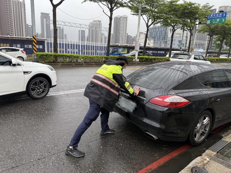 在員警的努力下，一位熱心貨車司機也主動加入協助，最後終於成功將車輛移至路旁。圖：讀者提供