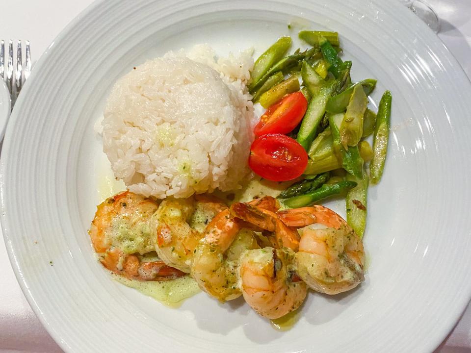 Shrimp, rice, tomatoes, asparagus on a white plate