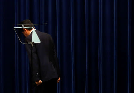 Japan's Prime Minister Shinzo Abe bows to Japanese national flag during a news conference at his official residence in Tokyo, Japan, September 25, 2017. REUTERS/Toru Hanai