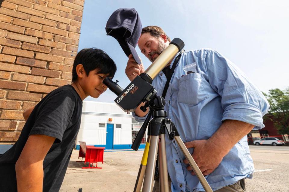 Luis Amaya, 9, from Houston looks at the sun through a telescope from Washington State art professor Travis Krause outside of the Hillsboro court house in Hillsboro on Monday, April 8, 2024. Chris Torres/ctorres@star-telegram.com