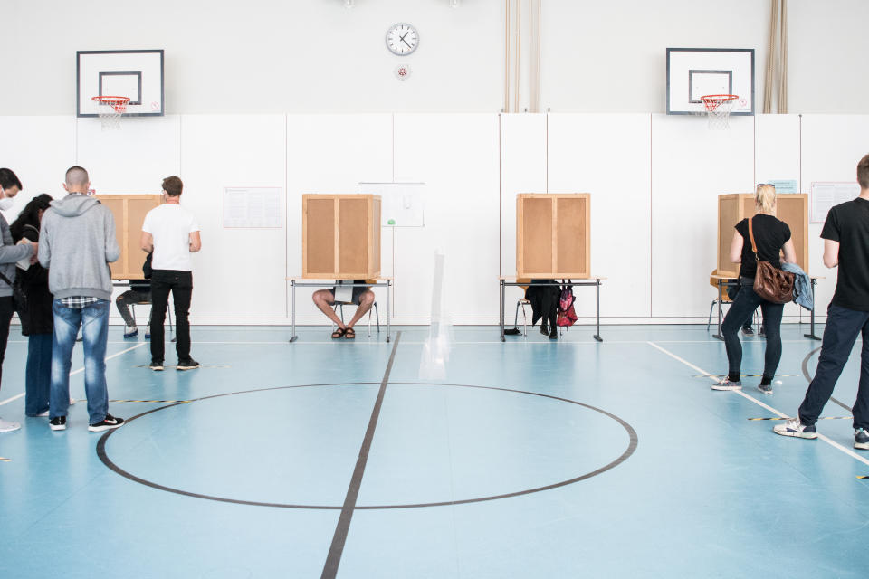 Wähler bei der Stimmabgabe in einem Berliner Wahllokal in einer Turnhalle am 26.9. 2021. 