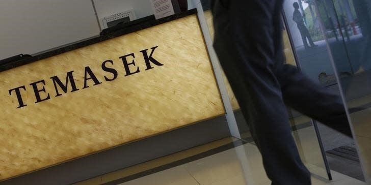 A man passes a logo of state investor Temasek Holdings at their office in Singapore July 8, 2014. REUTERS/Edgar Su