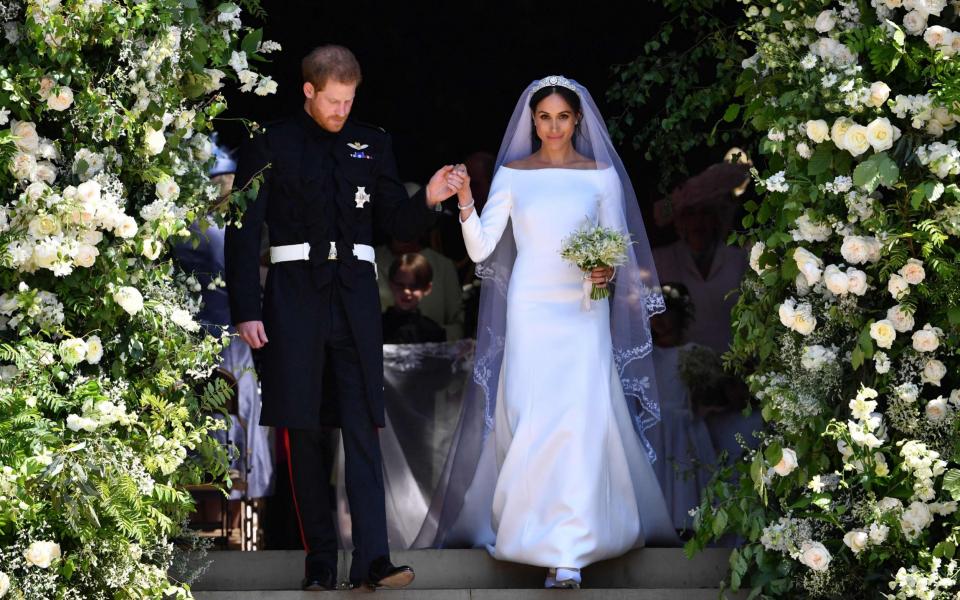 Harry, Duke of Sussex and his wife Meghan, Duchess of Sussex walk down the west steps of St George's Chapel, Windsor Castle, in Windsor, after their wedding ceremony - AFP/Ben Stansall