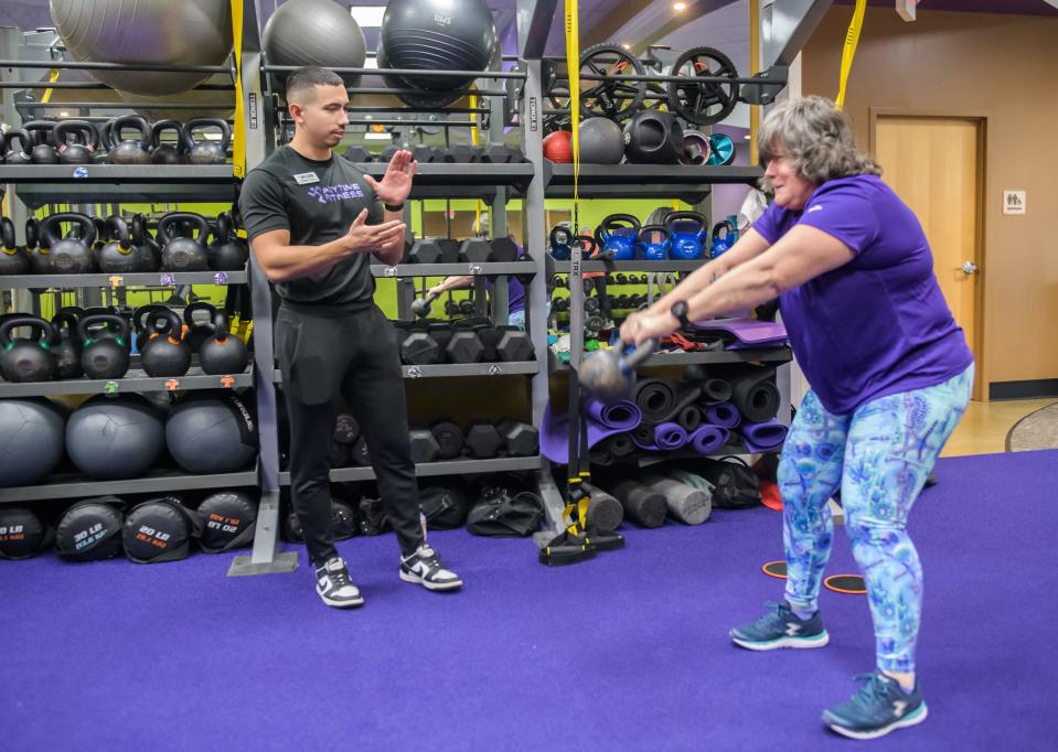 Personal trainer Brandon Crose encourages Maggie Zeman of Peoria Heights in a session at Anytime Fitness, 1320 W. Commerce Drive in Peoria.