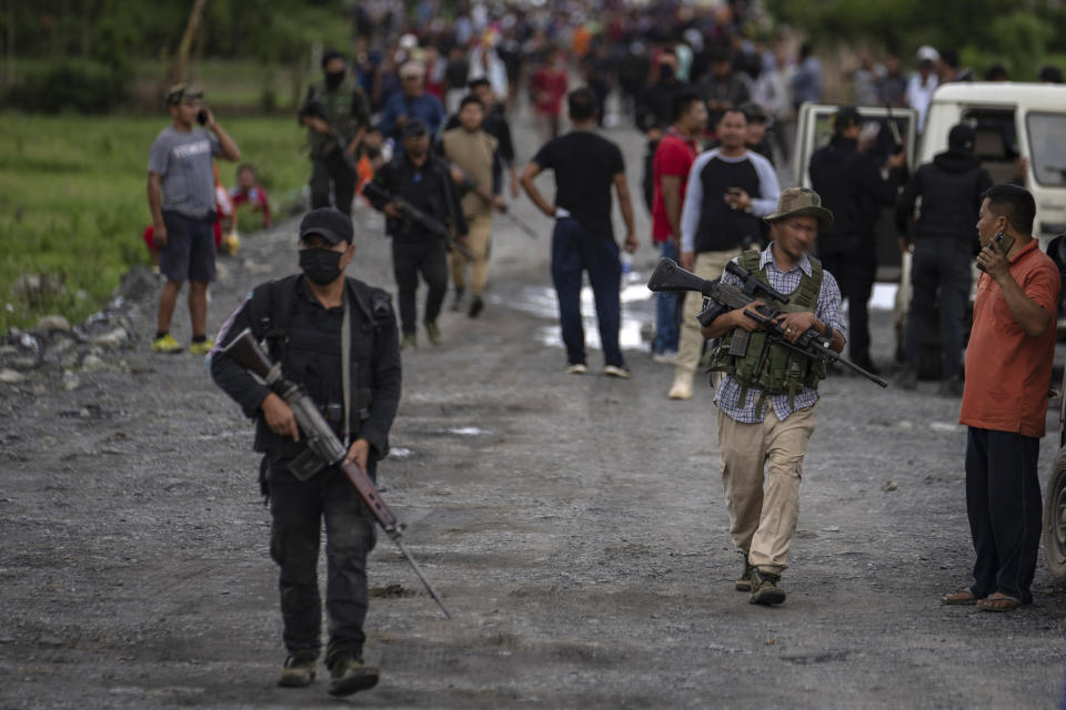 Armed Meitei community members carry automatic weapons as they rush towards a hillock where a firing incident was reported in Kangchup, near Imphal, capital of the northeastern Indian state of Manipur, Thursday, June 22, 2023. Manipur is caught in a deadly conflict between two ethnic communities that have armed themselves and launched brutal attacks against one another. At least 120 people have been killed since May. (AP Photo/Altaf Qadri)